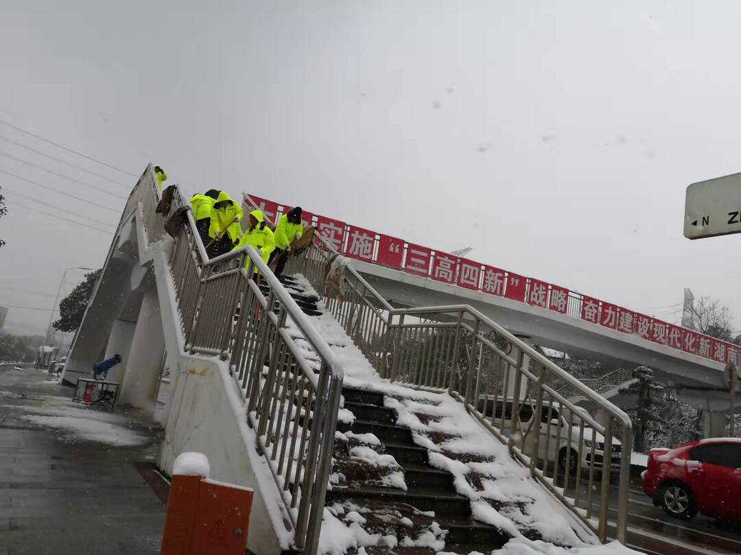 捞刀河街道在辖区内人行天桥等地开展撒盐除雪